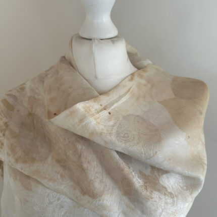 Cream pure silk damask long scarf with fine silk tassels has been eco printed with grey cotinus and brown sycamore prints and displayed on a white dress mannequin